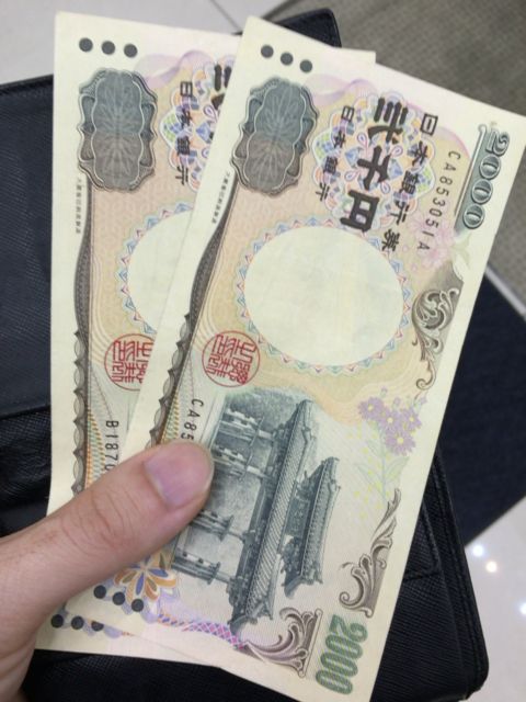 2000円札2枚を持つ人