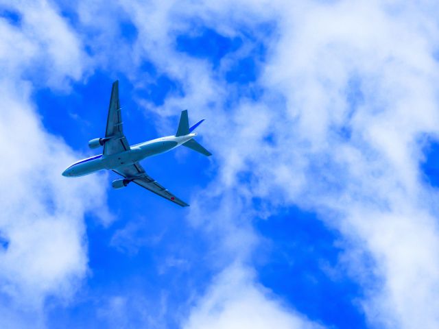 青空と雲の中の飛行機