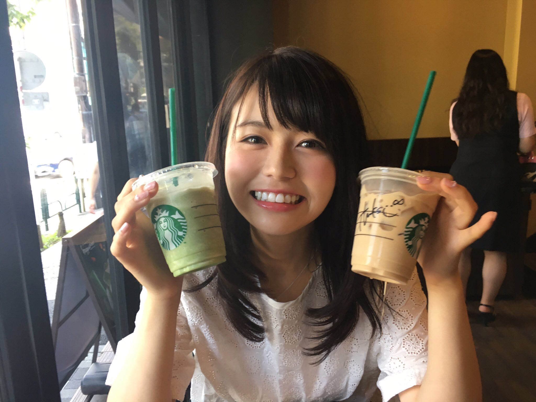 スタバのドリンクを両手に持つ女性