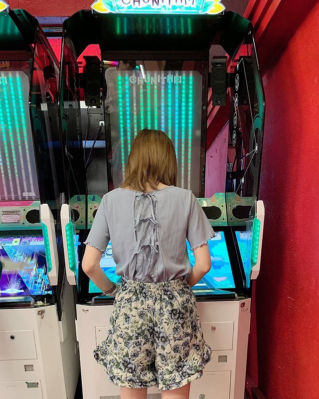 ゲームセンターでゲームをする女性後ろ姿