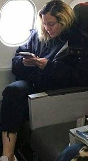 飛行機の客席に座っている外国人女性