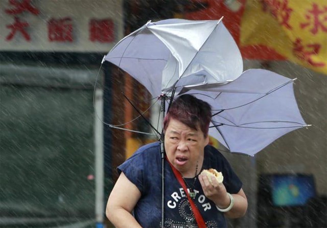 傘が裏返っている女性