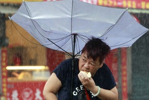 傘が裏返っている女性