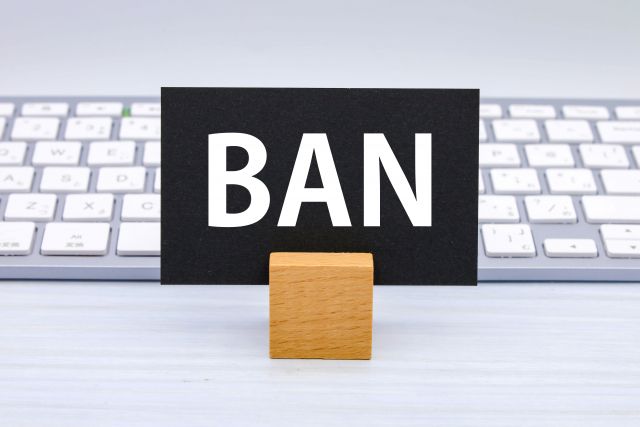 キーボードの前に置かれたBANと書かれた黒い紙