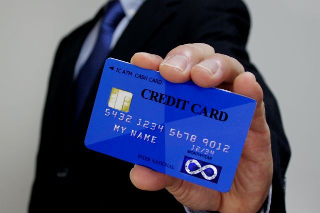 青いクレジットカードをドヤってみせる男性