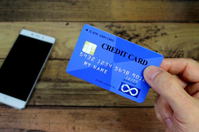 青いクレジットカードとスマホ