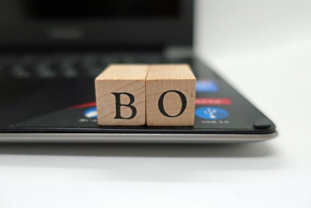 ノートパソコンの上に置かれた「B」と「O」のブロック