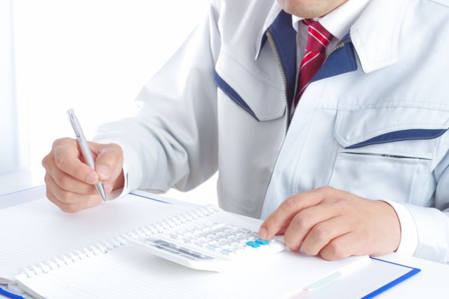 作業服を着て計算する男性