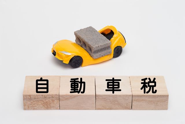 ブロックに潰される車と自動車税おの文字