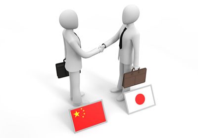 中国人とのビジネスで握手する人形