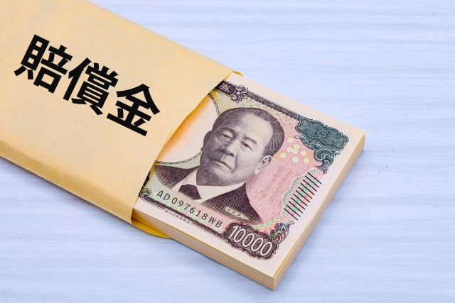 賠償金と書かれた封筒に入った大金