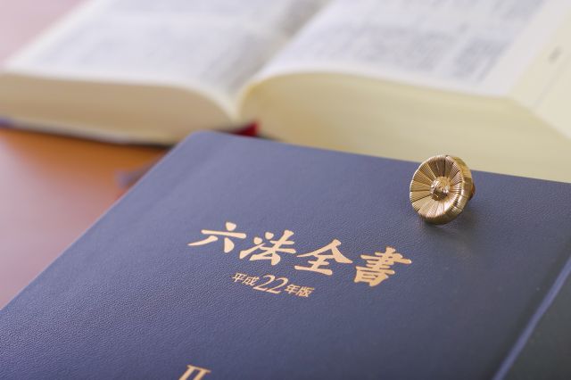 六法全書と弁護士バッチ