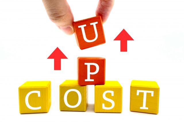 COST UPのサイコロをつまみ上げる手