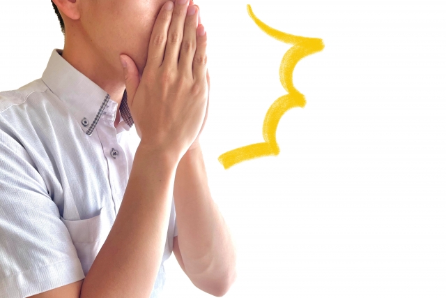 顔を手で覆って驚く男性