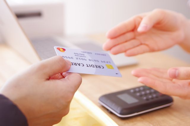 クレジットカードを定員に渡す客