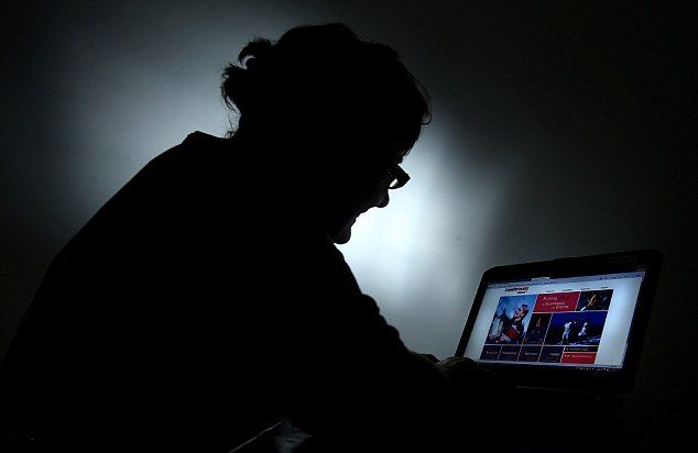 暗闇の中でパソコンを操作する男性