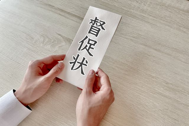 督促状を両手で持つ人