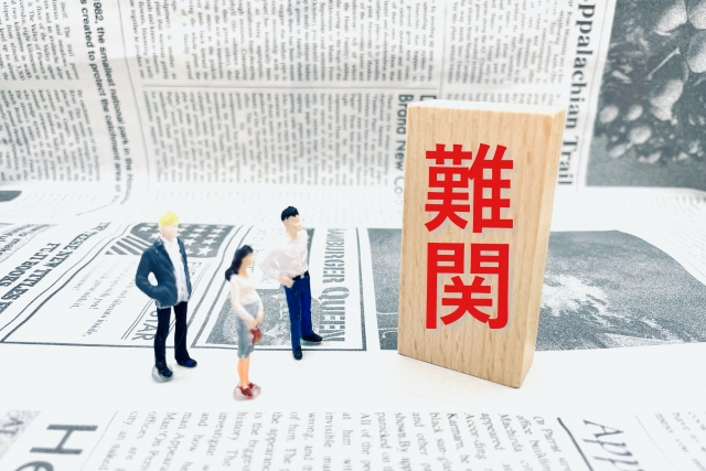 英字新聞と難関の文字を見る人形