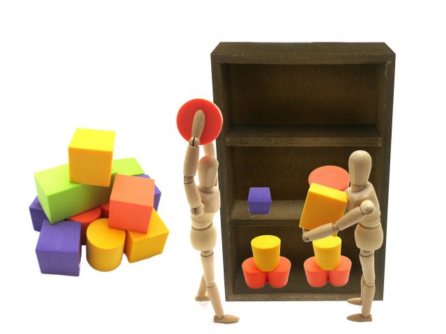 棚にブロックを並べる人形たち