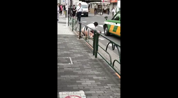 路上で男性に押し倒されている女性