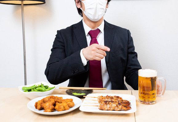 マスクをして飲み会に参加する男性