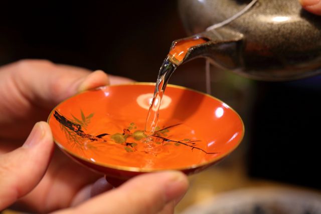 盃に酒をつぐ