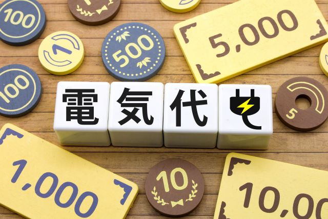 電気代と書かれたサイコロとお金のおもちゃ