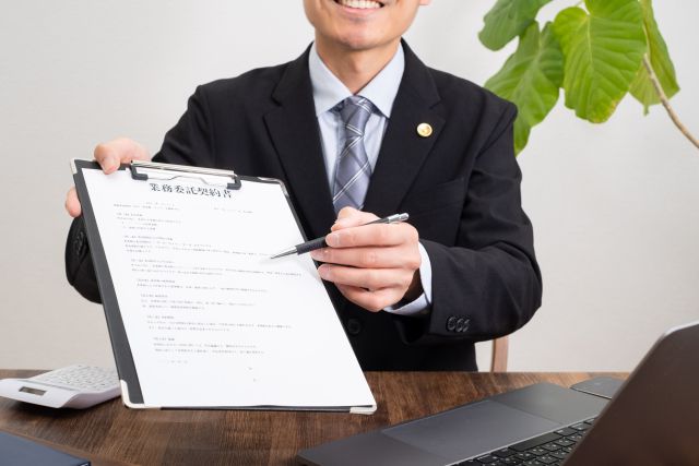 書類を出して説明する弁護士