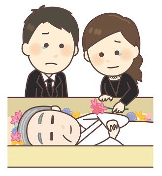 父親の棺にお花をいれる夫婦