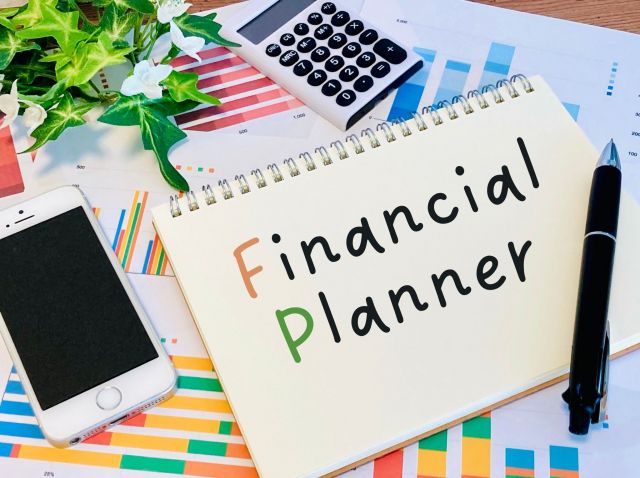 financial Plannerと書かれたｎ画用紙とスマホとペン