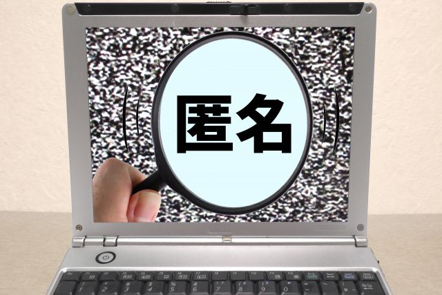 パソコンの画面に写っている匿名の文字を拡大する虫メガネ