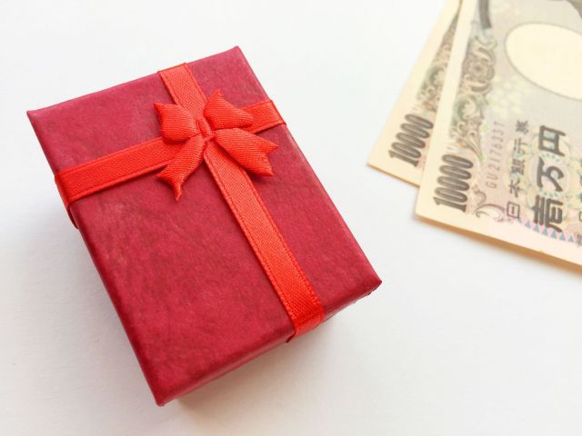 赤い包装紙に包まれたプレゼントと2万円