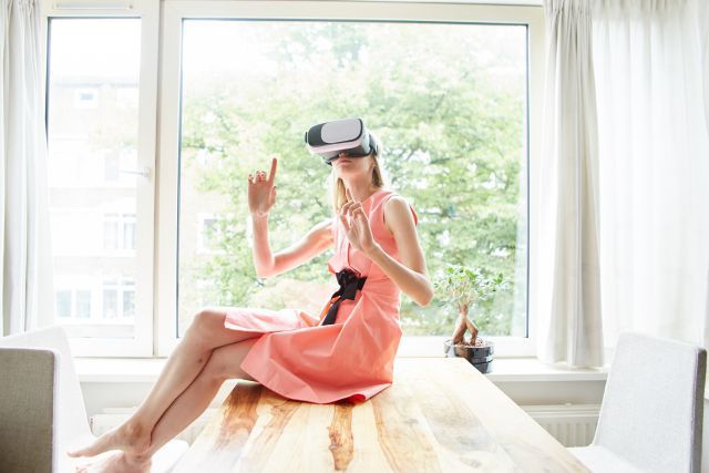 VRをつけてテーブルに座る女性