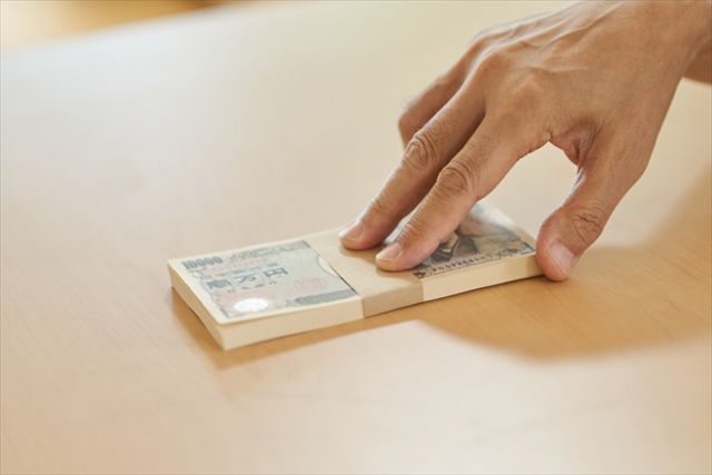 100万円を差し出す手
