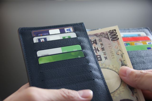 財布から5000円を出す手