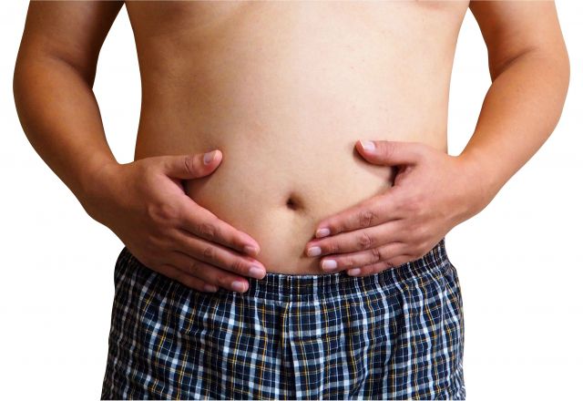 お腹を触る半裸の肥満男性