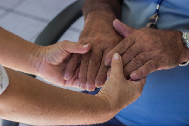 老人の手を握る医師の手
