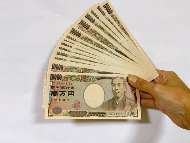 たくさんの1万円札を持つ手