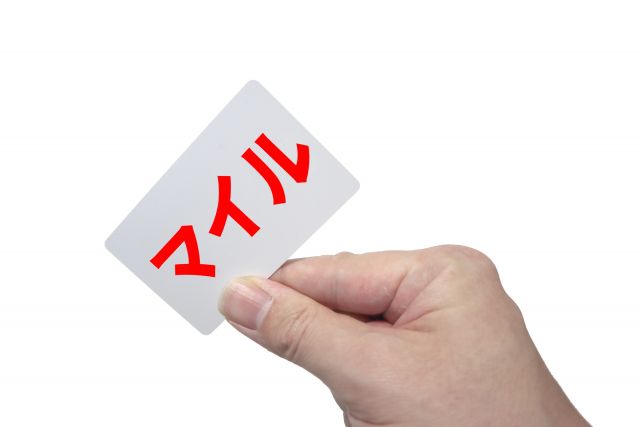 赤い字でマイルと書かれたカードを持つ人
