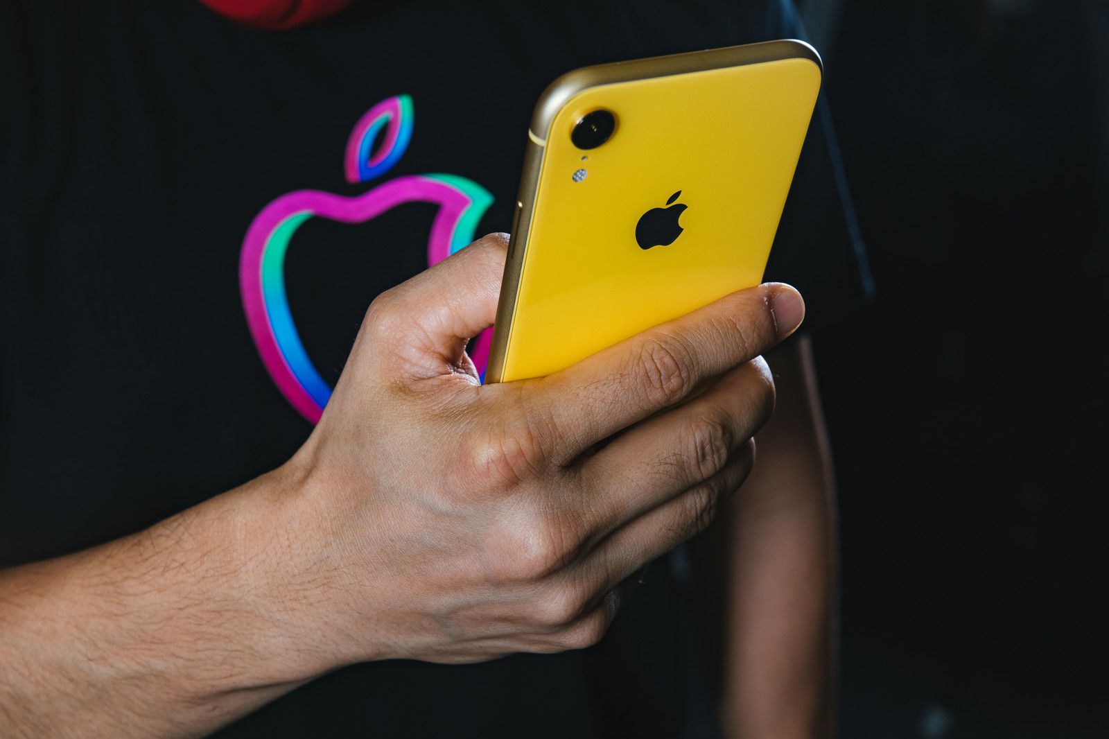 黄色のiPhone XRを持つ男性