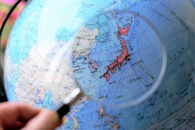 地球儀の中にある日本を虫眼鏡で見る