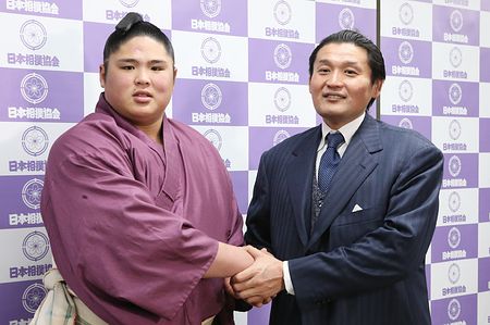 親方と手を取り合う力士