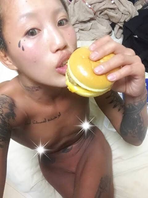 ハンバーガーを食べる刺青女性