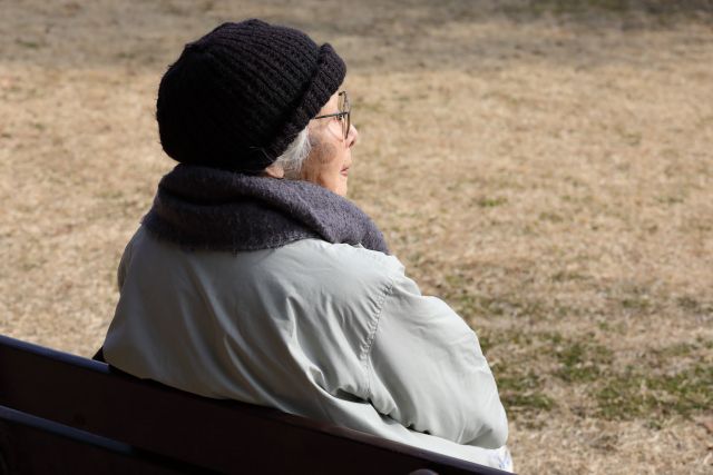 公園のベンチに座る老女