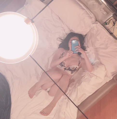 ベッドの上で自撮りする女性