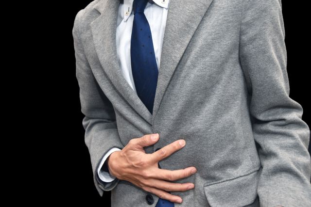 お腹を押さえる男性