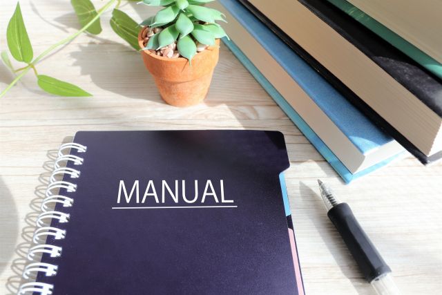 Manualと書かれたノートとペン