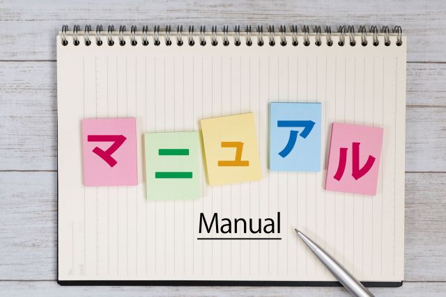 ノート書かれたマニュアルの文字とペン