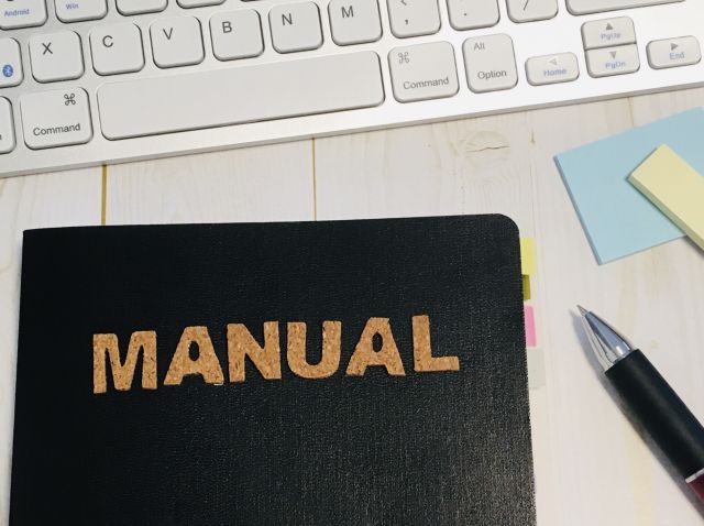 MANUALと書かれた黒い本とペン
