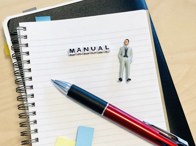 Manualと書かれたノートとその上に置かれたペン